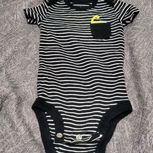 Cute striped onesie with dinosaur in pocket